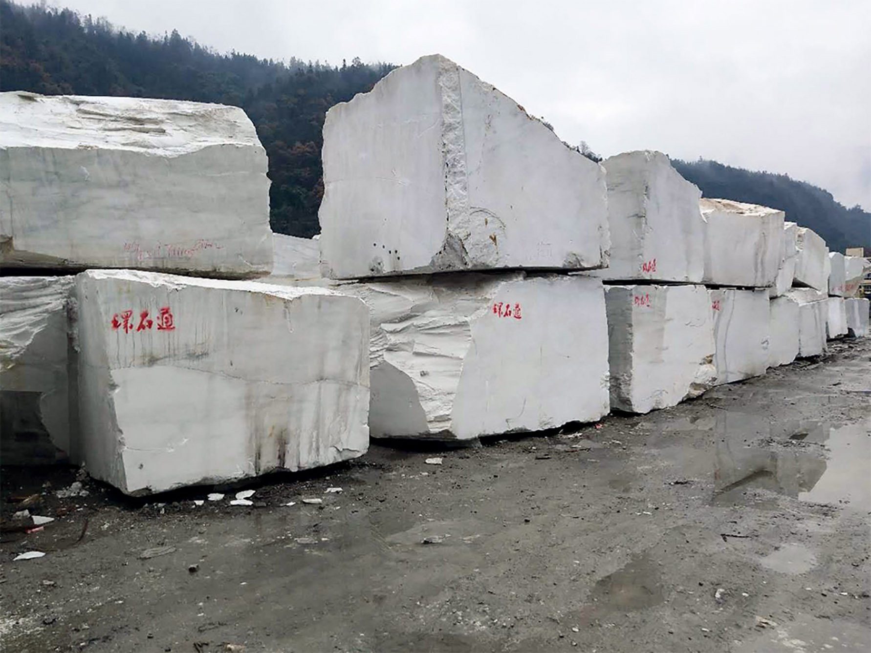 Marble blocks marked 环石通 stacked in the yard