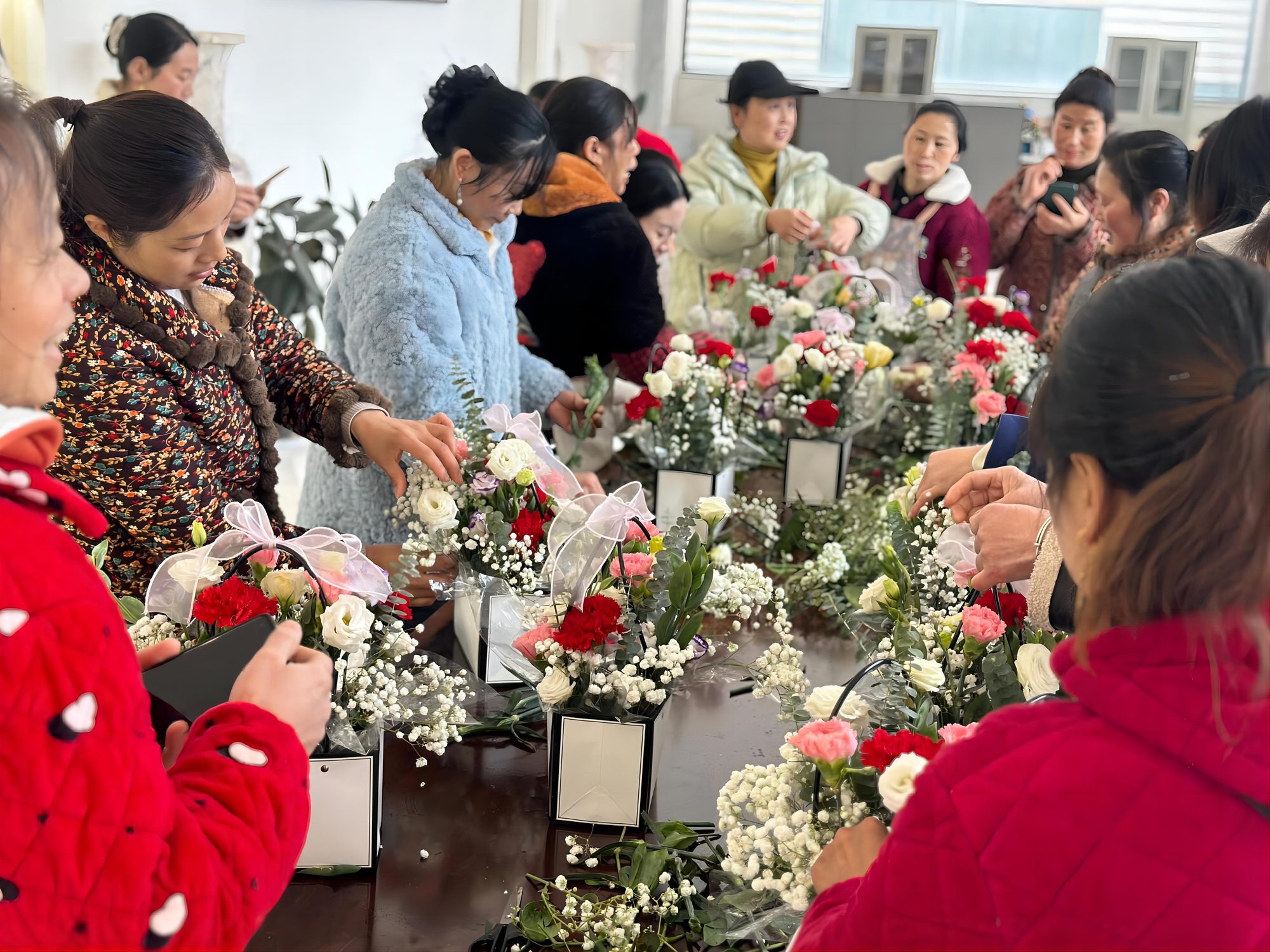 Staff arranging flowers at a long table in the showroom