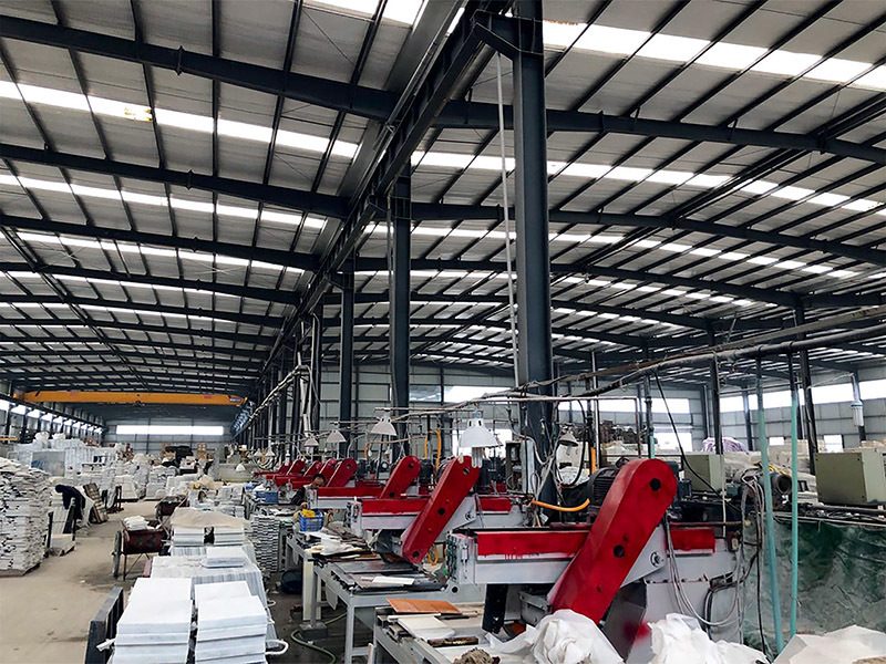 A long automatic polishing line running down the workshop with red machine heads