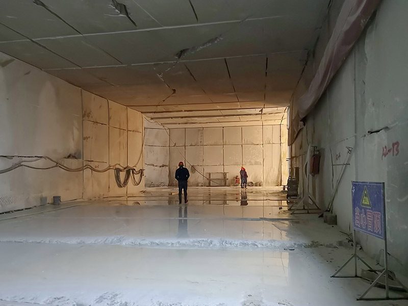 The wet floor of a mining chamber with the sawn wall behind
