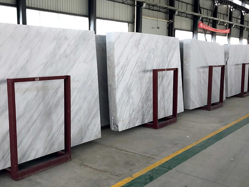 Polished white marble slabs standing on A frames in the warehouse