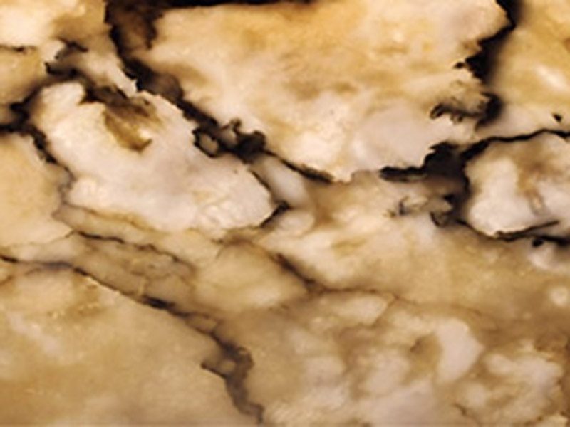 Translucent Arabescato Violet lit from behind, glowing amber and honey with dark brown veins